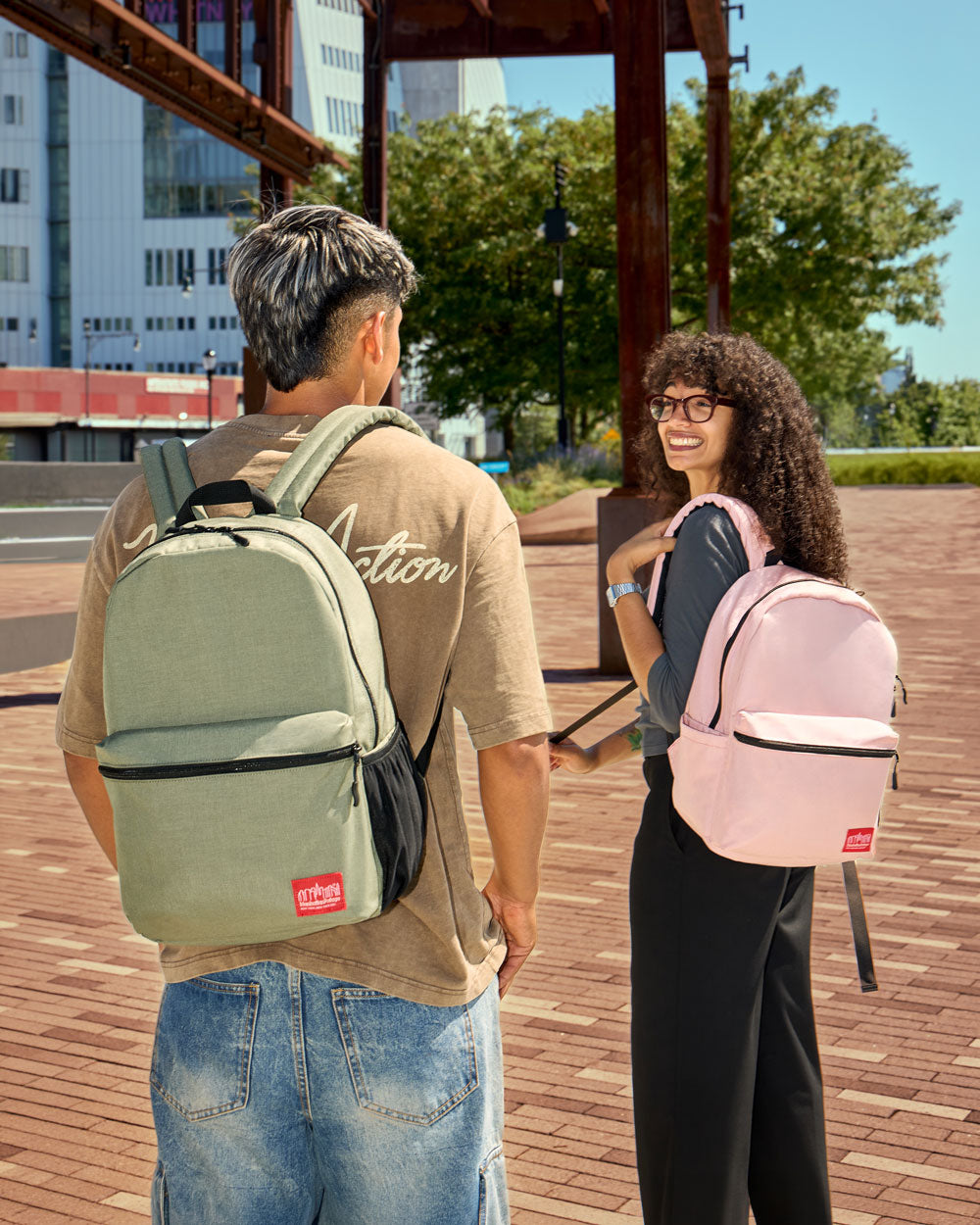 Two models wear Manhattan Portage Daffodil Backpack Blossom